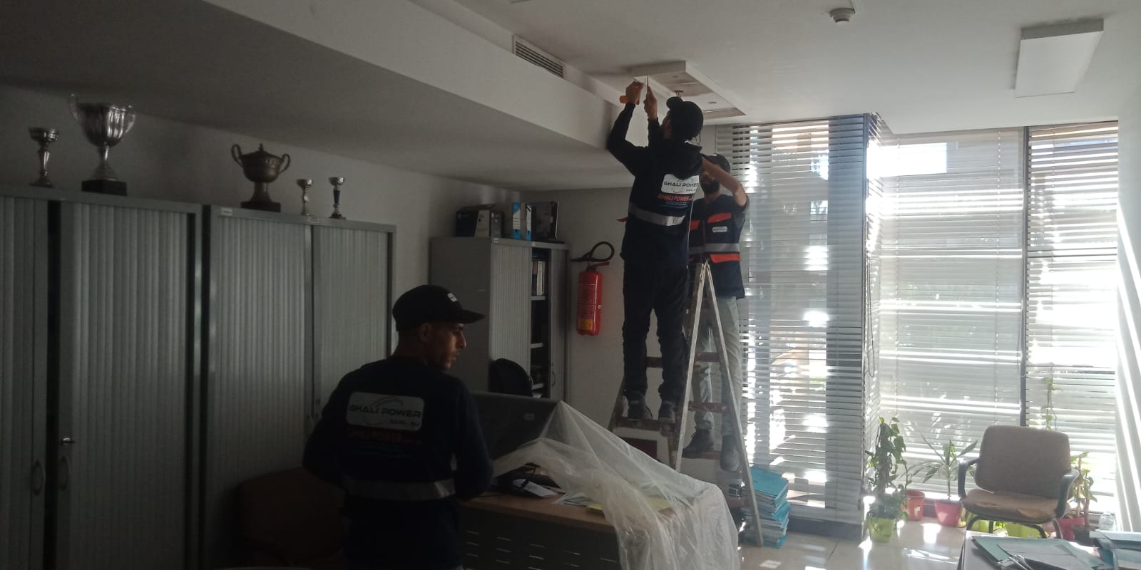Techniciens Ghali Power réalisant une installation électrique dans des bureaux