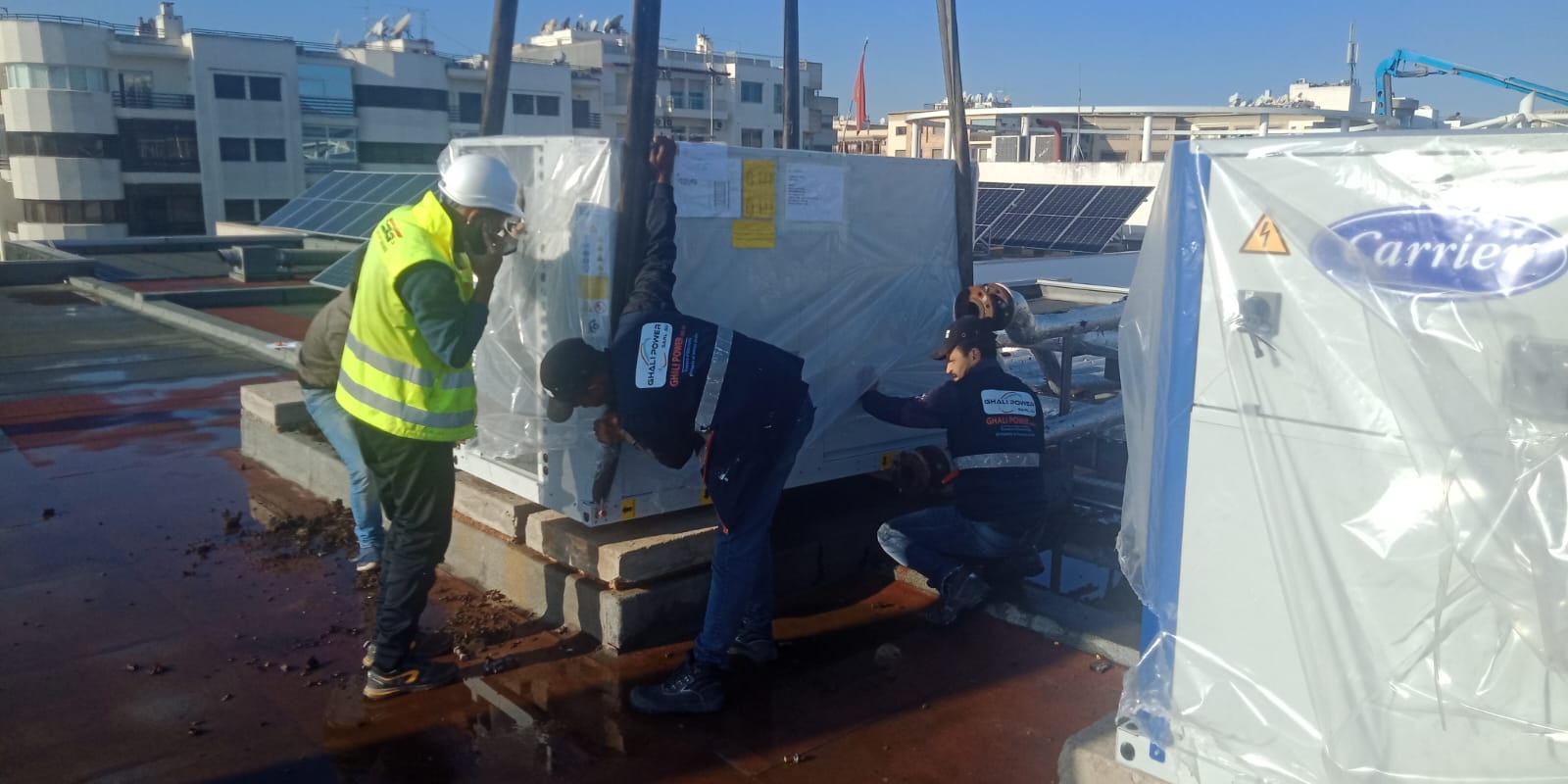 Techniciens Ghali Power installant des équipements de climatisation en toiture