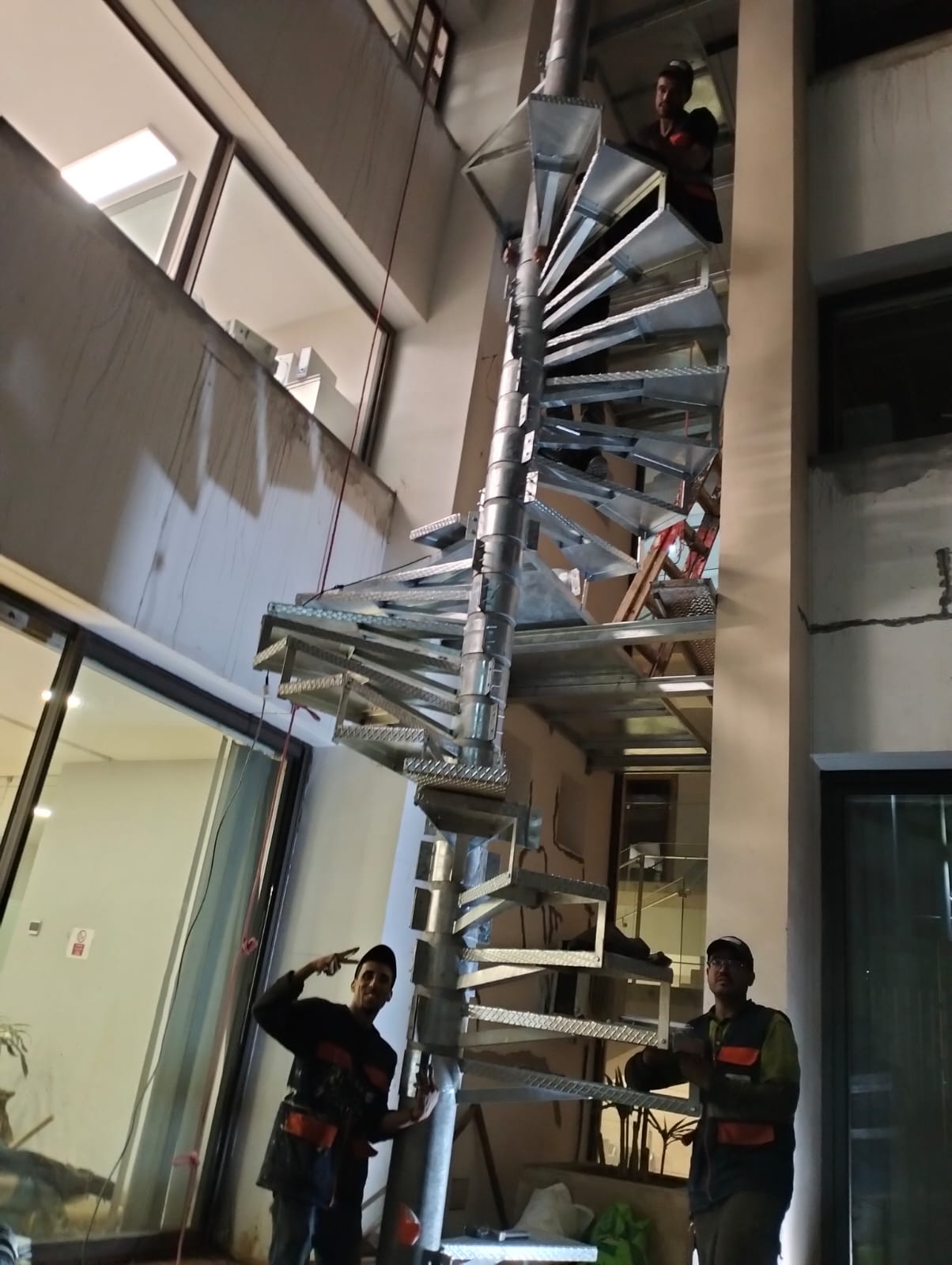 Techniciens Ghali Power installant un escalier métallique en colimaçon